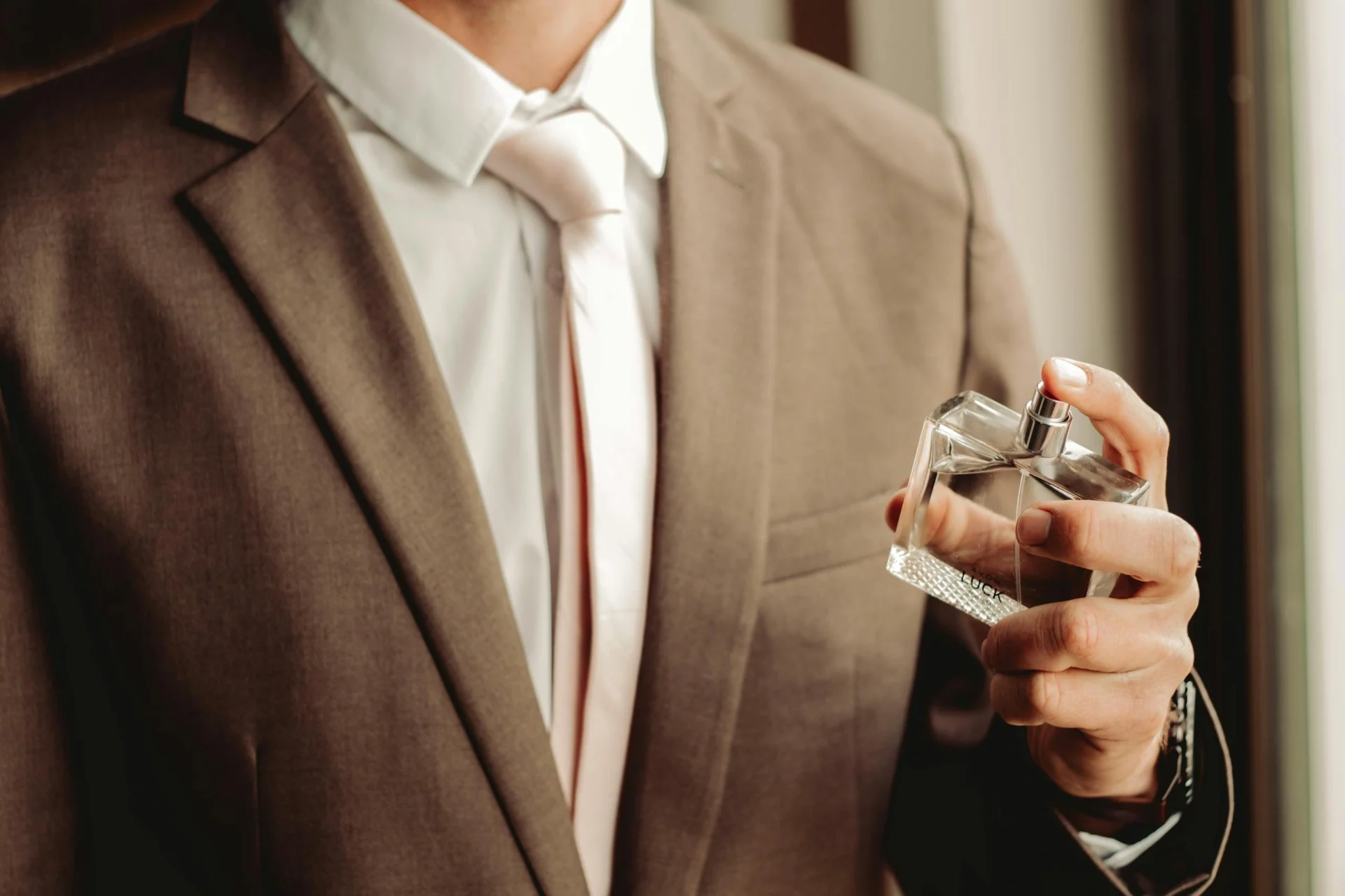 RangeKhushboo - man wearing suit and necktie with perfume bottle 10604607 scaled 1